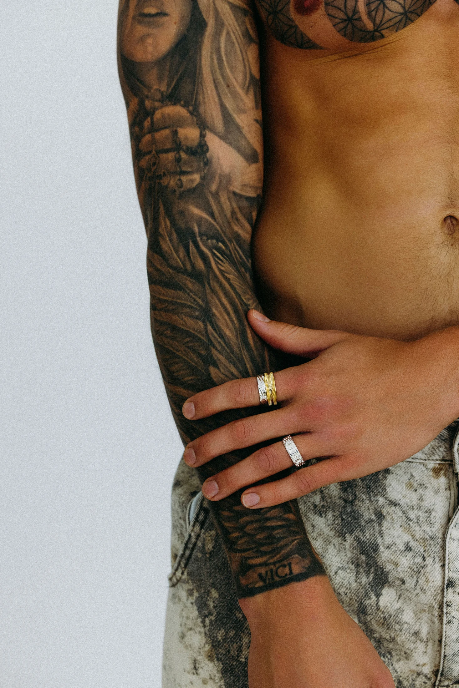 Ring detail on the hands of a tattooed model